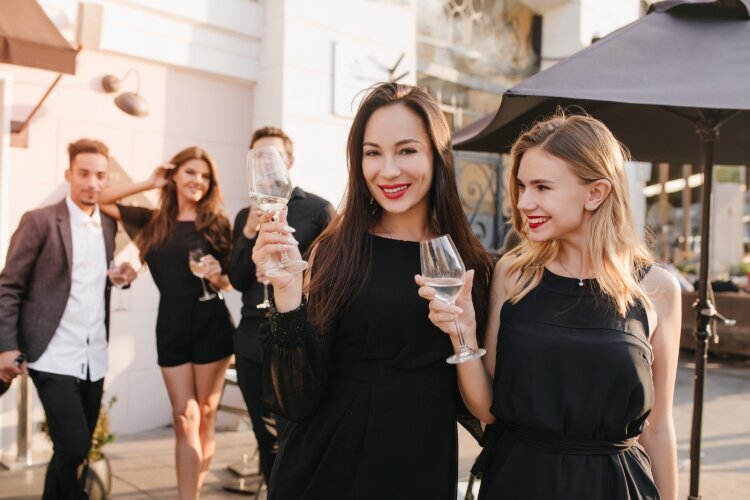 outdoor_portrait_enthusiastic_brunette_women_black_dresses_posing