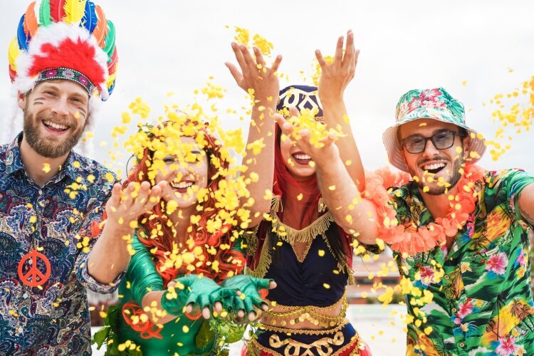 happy_dressed_people_celebrating_carnival_party_throwing_confetti