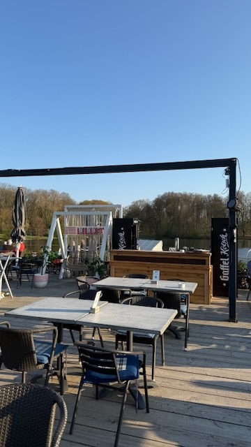 Öffentlicher Biergarten des Haus am See in der Abendsonne mit Blick über den Decksteiner Weiher